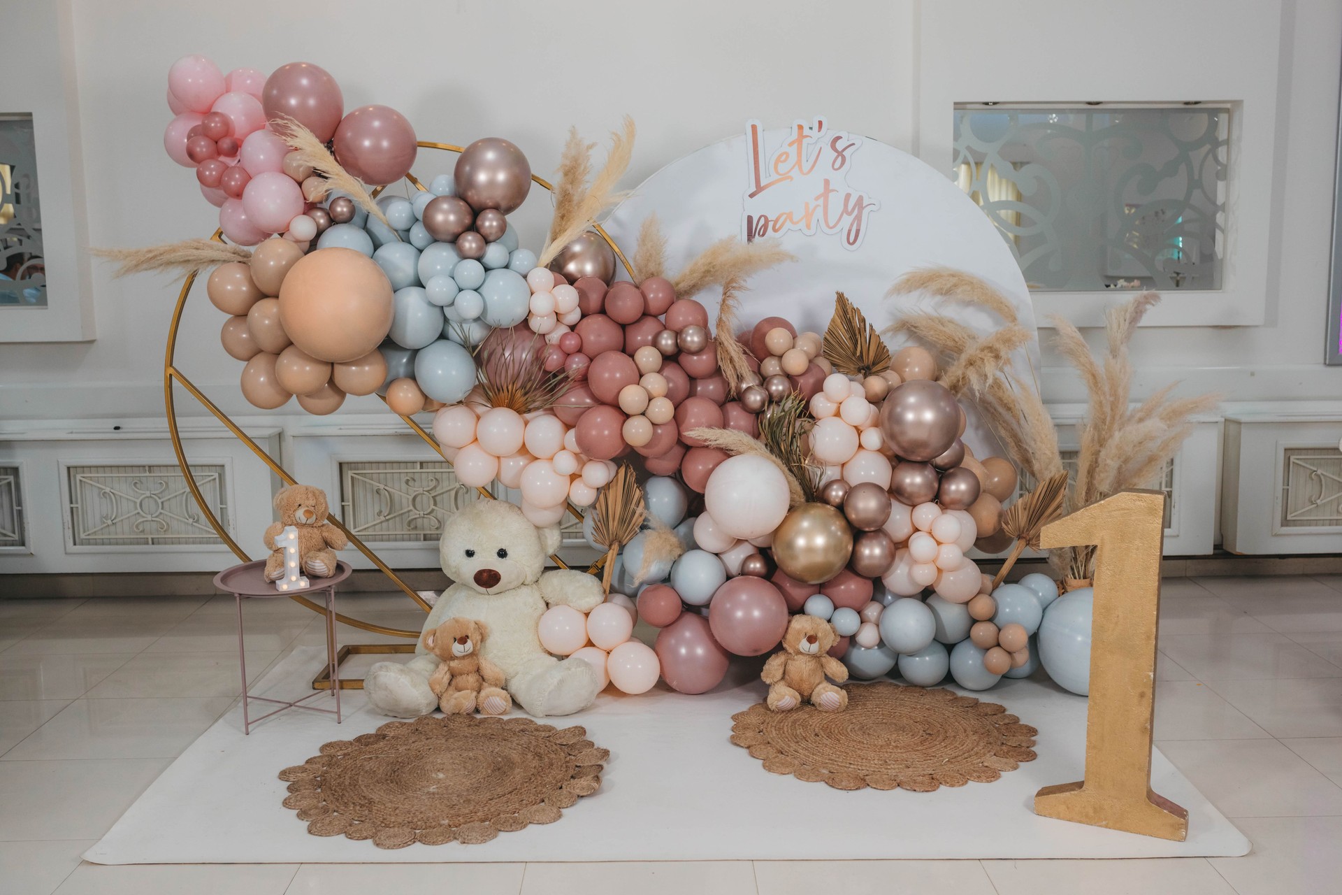 Soft colored party decoration with balloons, teddy bear and number one.